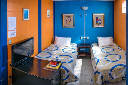 2 camas en una habitación con paredes azules en Hostal Guatefriends, en Guatemala