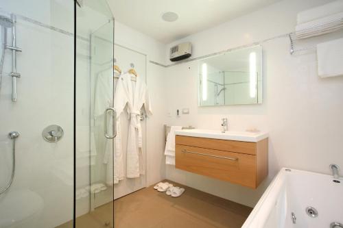 y baño con bañera, lavamanos y ducha. en Hotel St Clair en Dunedin