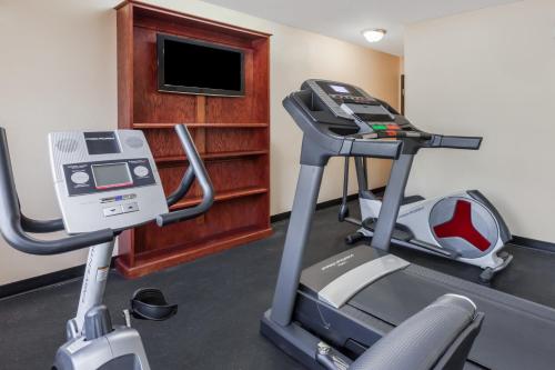 a room with a gym with a treadmill and a television at Super 8 South by Wyndham in Bowling Green