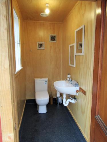 a bathroom with a toilet and a sink at Greenstone Retreat in Kumara