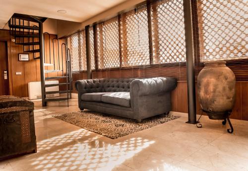 a living room with a couch and a large window at Hotel Santa Isabel in Toledo