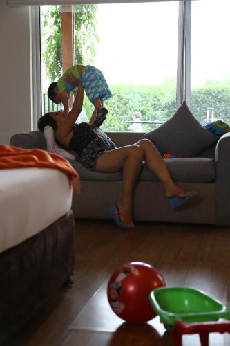 a woman in a dress sitting on a couch at Casa Andina Standard Chincha in Chincha Alta