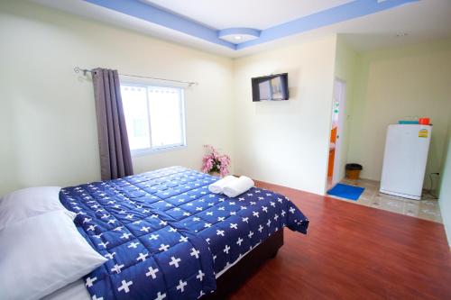a bedroom with a bed with a blue blanket at Bannrommai Sattahip in Sattahip