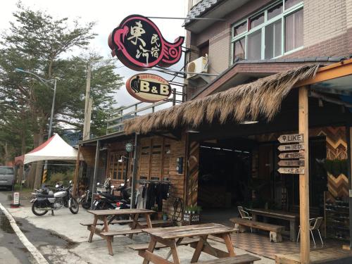 a restaurant with picnic tables outside of a building at Donghe surf shop & Hostel in Donghe