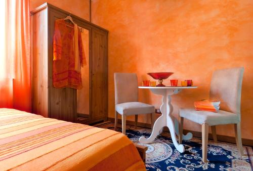 a bedroom with a table and two chairs and a bed at Villa Ferrari, Le Betulle in San Maurizio dʼOpaglio