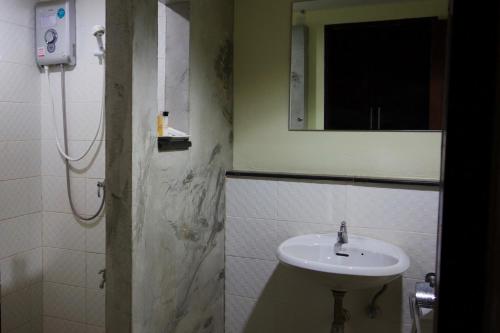 een badkamer met een wastafel en een spiegel bij Airport Resident in Chiang Mai