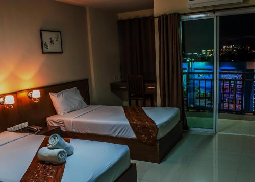 a hotel room with two beds and a balcony at Airport Resident in Chiang Mai