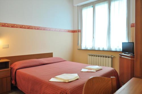 a bedroom with a red bed with two towels on it at Albergo Villa Margherita in Tiglieto