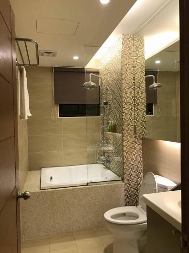 a bathroom with a shower with a toilet and a tub at Early Summer in Luodong