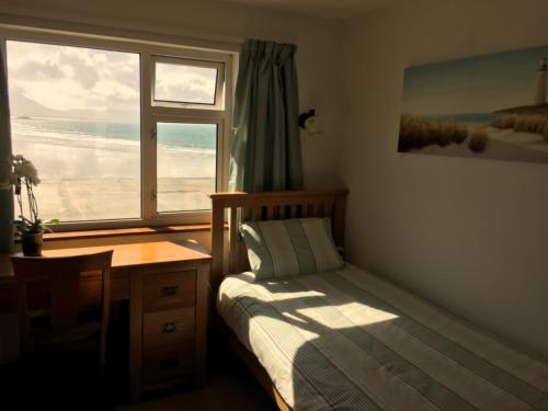 a bedroom with a bed and a desk and a window at O'Neill's Bed&Breakfast in Ballyheigue