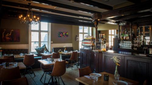 ein Restaurant mit Tischen und Stühlen und eine Bar in der Unterkunft Hanze Hotel Zwolle in Zwolle