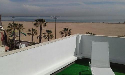 a balcony with a view of a beach and palm trees at El Globo in Valencia