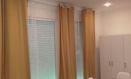 a room with a window with yellow curtains at El Globo in Valencia