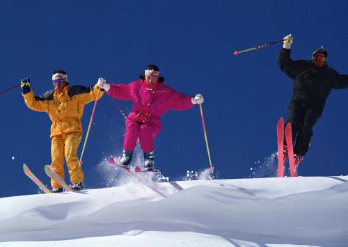 a group of three people jumping in the snow on skis at Hotel Resort Inn Niseko in Niseko
