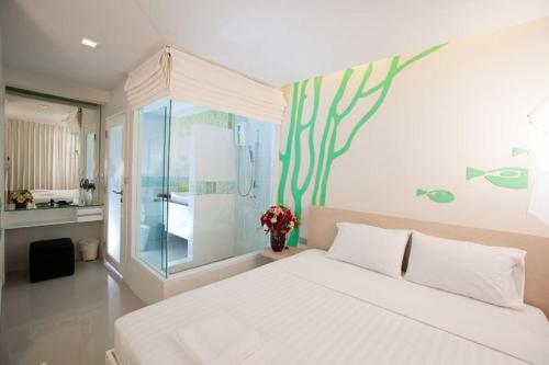 a bedroom with a large white bed and a window at R-Con Blue Ocean in Pattaya