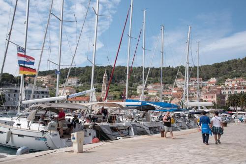 a group of people walking on a dock with boats at Old Town Hvar Apartment in Hvar