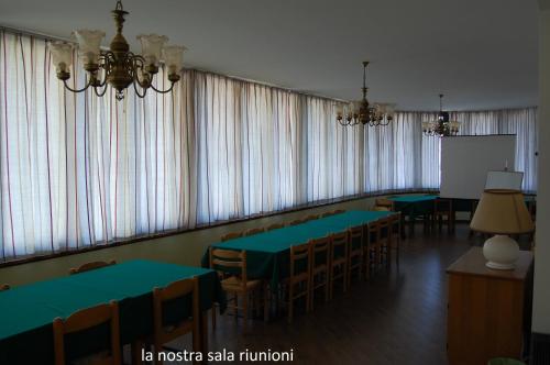 a conference room with green tables and chairs and a whiteboard at La Rotonda in Pergine Valsugana