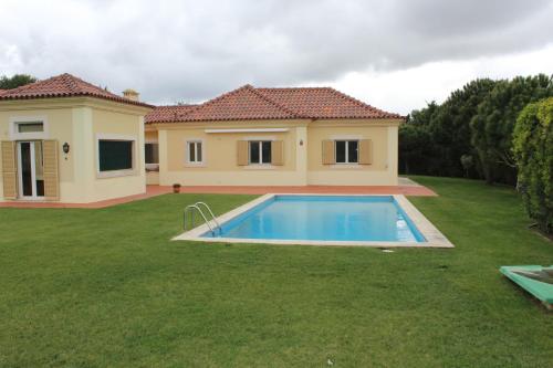 a house with a swimming pool in a yard at Dunas Golf House in Cascais