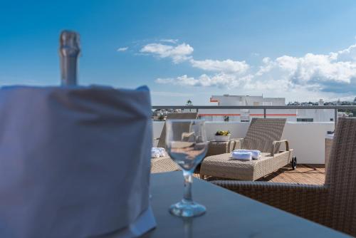 a glass of wine sitting on a table on a balcony at City Center Hotel in Rhodes Town