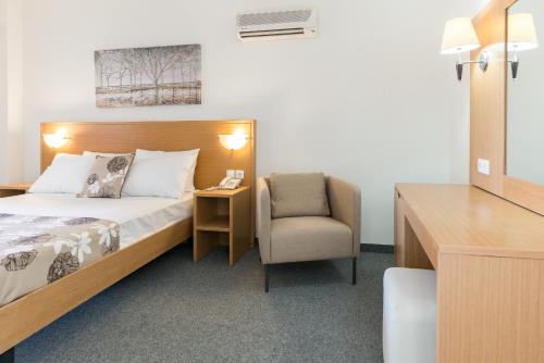 a hotel room with a bed and a chair at City Center Hotel in Rhodes Town