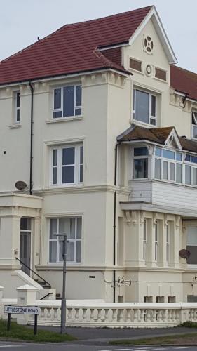 a white house with a street sign in front of it at Seabreeze in Littlestone-on-Sea