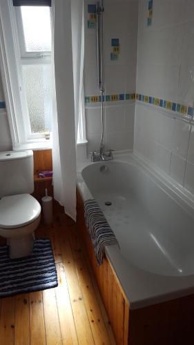 a bathroom with a bath tub and a toilet at Seabreeze in Littlestone-on-Sea