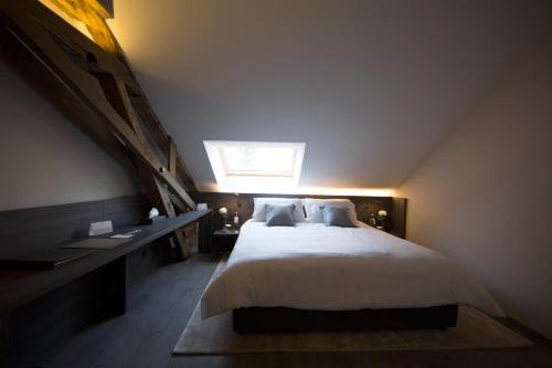 a bedroom with a large bed with a skylight at Etoile de Pompadour in Arnac-Pompadour
