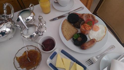 a white table topped with a plate of breakfast food at Lochinver Guesthouse in Ayr