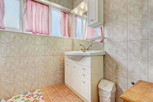 een badkamer met een wastafel en een spiegel bij Apartments Dragica 1251 in Fažana