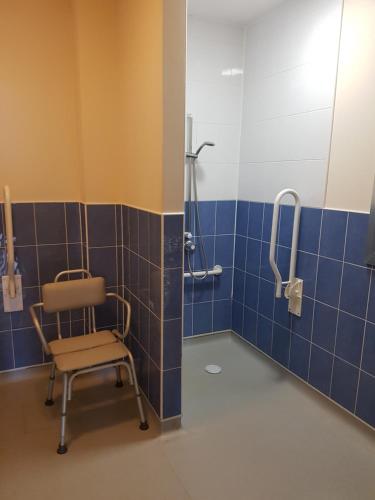 a bathroom with a chair and a shower at Ingoldale Park Apartments in Ingoldmells
