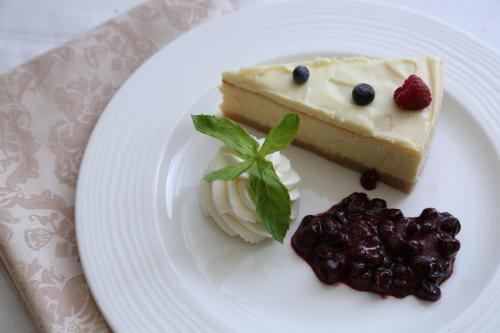a piece of cheesecake and berries on a white plate at Ambassador Hotel in Jerusalem