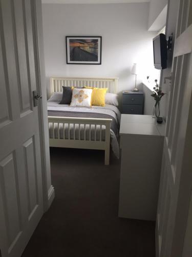 a bedroom with a bed with a pillow on it at Copper's Cottage in Sheringham