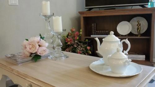 a table with a tea set and flowers on it at Luxury apartment Suite La Fontana in Lucca