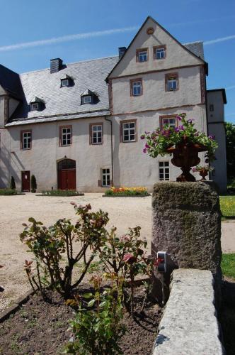 a large white house with flowers in front of it at Schloss Hotel Wallhausen in Wallhausen
