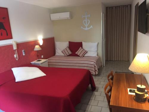 a hotel room with two beds and a couch at Lou Garbin in Saint-Laurent-dʼAigouze