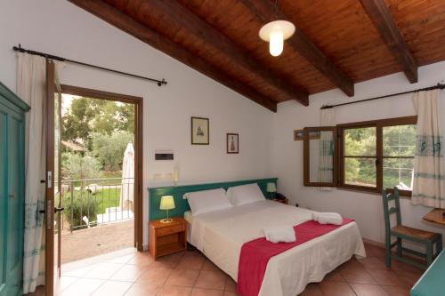 a bedroom with a bed and a balcony at Agri Resort San Giuliano in Santa Maria la Palma