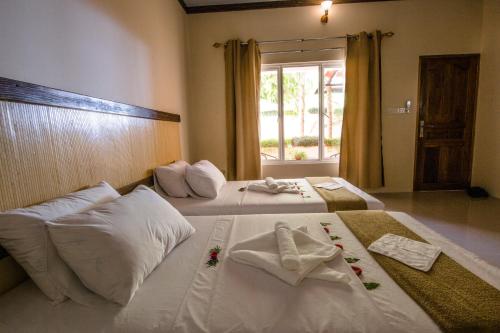 2 łóżka w pokoju z ręcznikami w obiekcie Ari heaven Thoddoo Maldives w mieście Thoddoo
