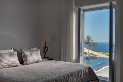 sypialnia z łóżkiem i widokiem na ocean w obiekcie Andromaches - by Senses Collection w mieście Pirgos