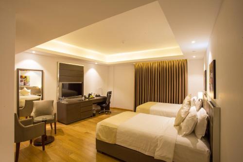 a hotel room with a bed and a desk at The Grandmark Dhaka in Dhaka