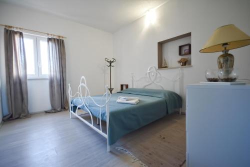 - une chambre avec un lit et une table avec une lampe dans l'établissement Apartments Bertetić, à Kanfanar