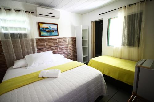 1 dormitorio con 2 camas y ventana en Casa da Albertina en Fernando de Noronha