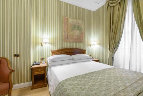 A bed or beds in a room at Gambrinus Hotel