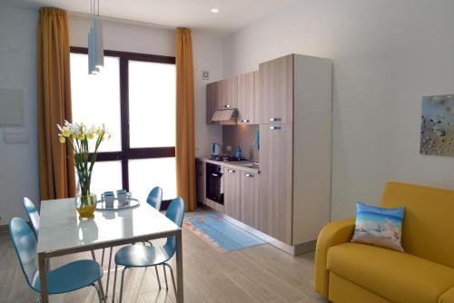 a living room with a table and a yellow couch at Appartamento Nonna Lina in Custonaci