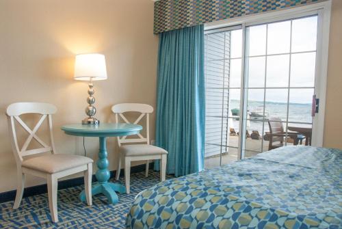 a hotel room with a bed and a table and chairs at Grand Beach Resort Hotel in Traverse City