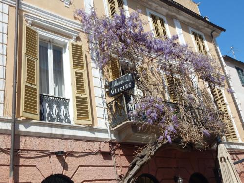 a building with a wreath of purple flowers on it at Hotel Glicine in Noli