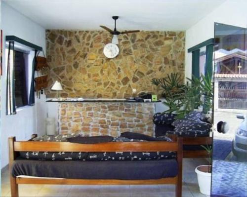 a room with a bench and a stone wall at Hotel Alaska in Peruíbe