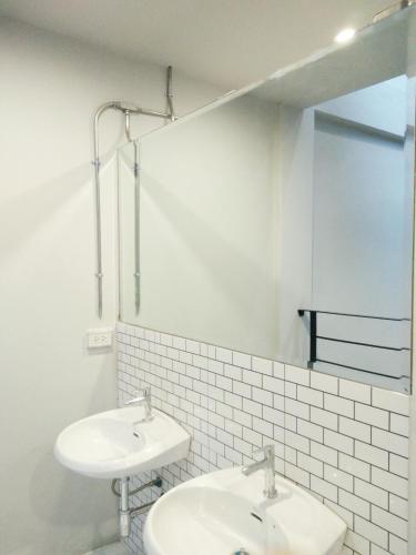 un bagno bianco con due lavandini e uno specchio di Warm Casa Chiangmai a Chiang Mai