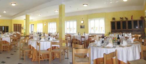a dining room with tables and chairs with white table cloth at Albergo Villa Margherita in Tiglieto