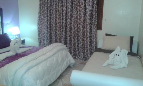a bedroom with two beds with stuffed animals on them at Hotel School Ersat Azrou in Azrou