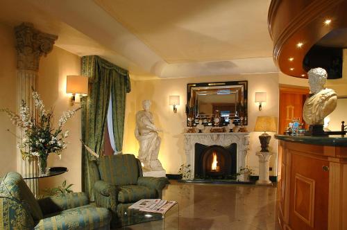 a living room with a fireplace and a statue of a man at Colonna Hotel in Frascati